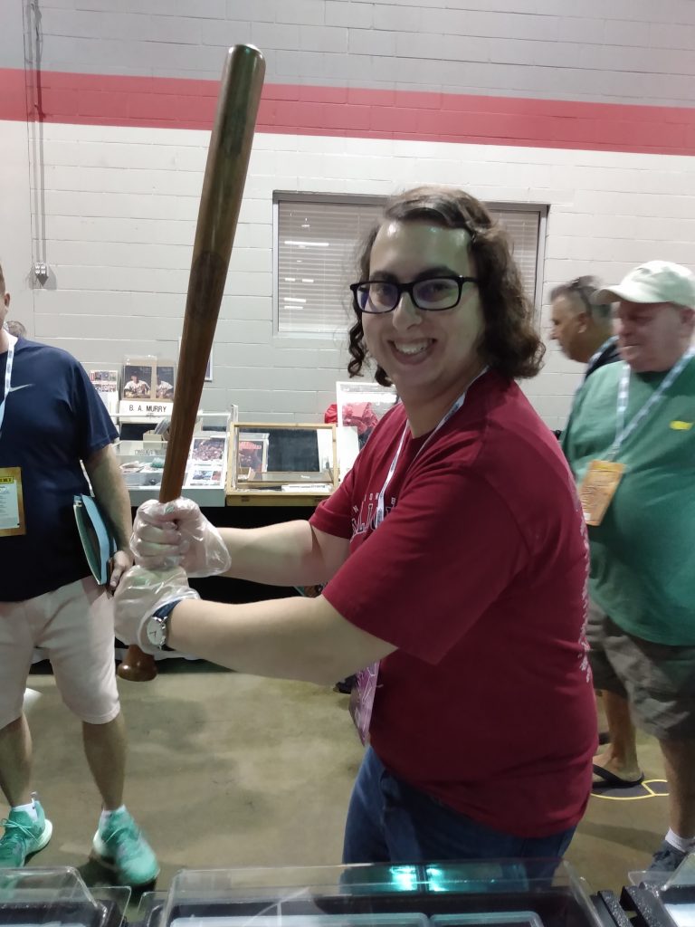 Danielle Solzman poses with a Babe Ruth bat.