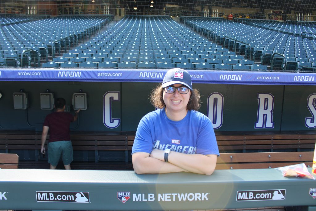 Danielle Solzman poses in the visitor's dugout along third base.